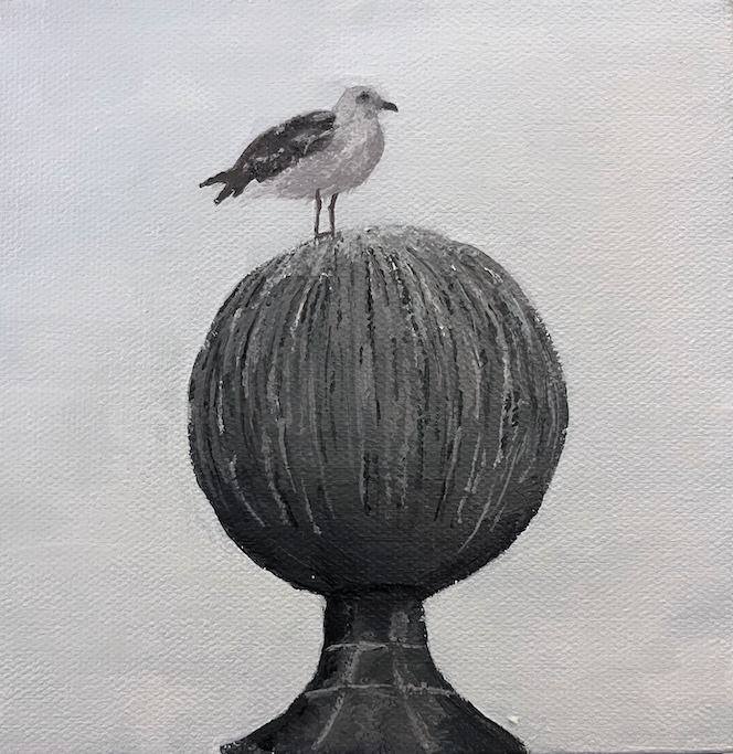 A black and white bird sits atop a large gray mental ball. There is bird poop on the ball. The sky is gray